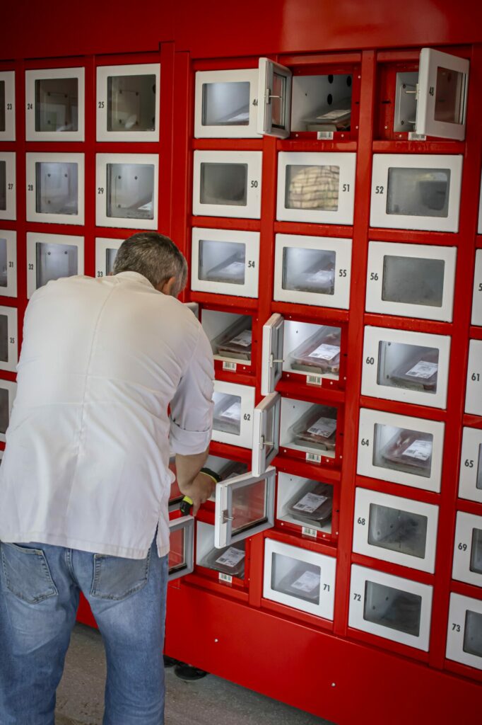Ein Metzger beim Auffüllen von Fleischschalen in ein vernetztes Automat-e-Schließfach